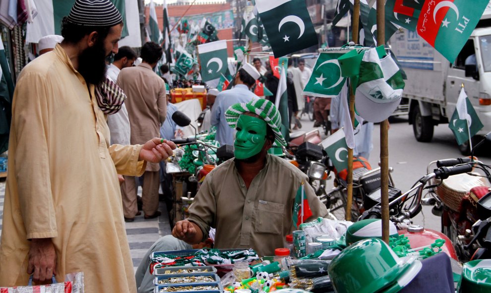 Un comerciante vende objetos con los colores de la bandera pakistaní para celebrar el Día de la Independencia, en Peshawar, Pakistán. REUTERS/Fayaz Aziz