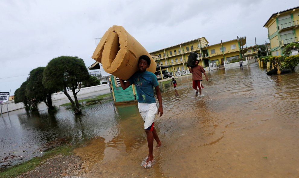 Un hombre lleva un colchón mientras abandona una escuela que ha usado como refugio  después del huracán Earl que ha golpeado en la ciudad de Belice, en Belice. REUTERS / Henry Romero