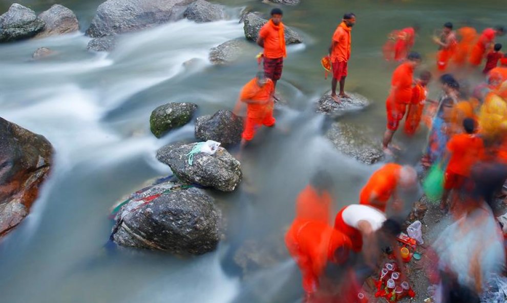 Un grupo de peregrinos hindús nepalíes, también conocidos como Bolboms, toman agua sagrada para rendir culto a Shiva, el dios de la creación y la destrucción, en el río Bagmati en Kathmandu, Nepal. EFE