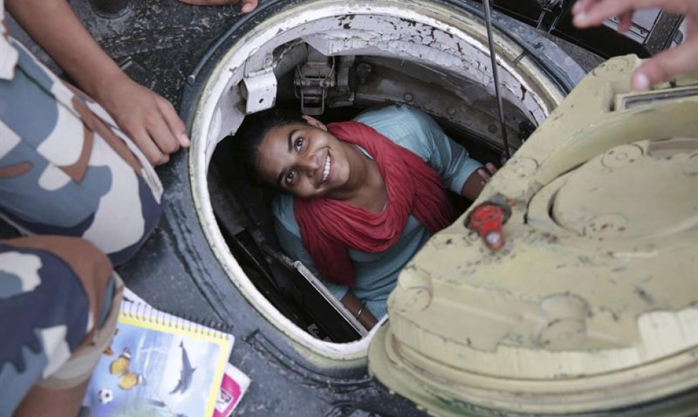 Una joven sonríe desde dentro de un tanque en la exposición "Conoce a tu ejército" en Amritsar (India). La exposición, organizada por el ejército indio, se celebra del 10 al 16 de agosto y tiene el objetivo de animar a los jóvenes a enrolarse en el ejérci