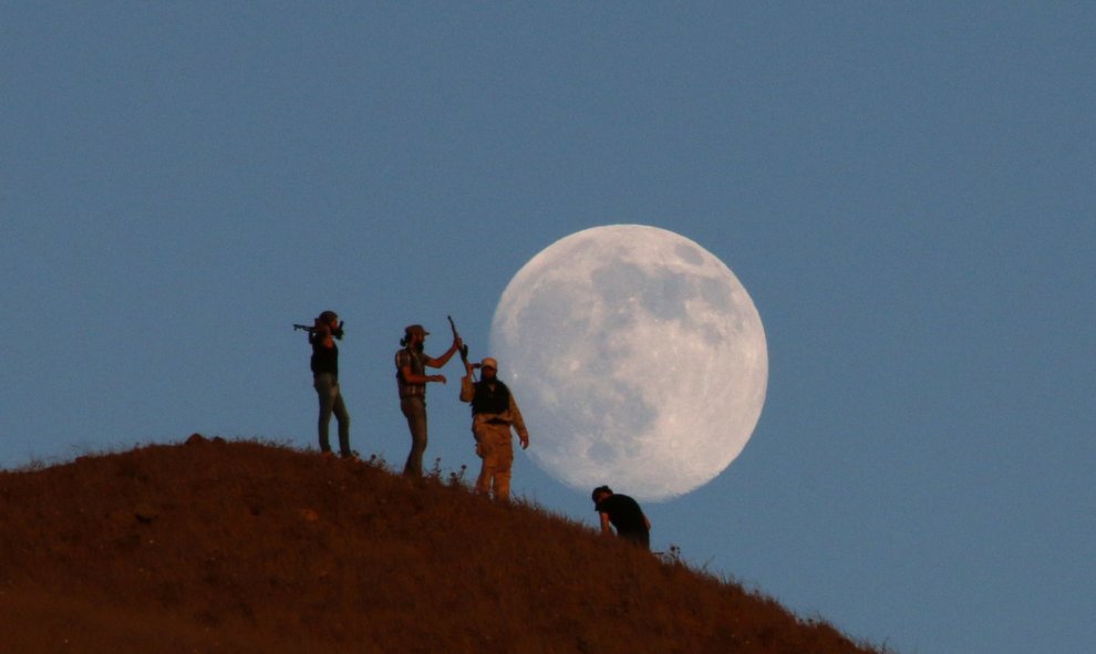 La armada libre del ejército sirio hace guardia encima de una colina mientras la luna se alza al fondo, en el sur de la ciudad de Nawa, Siria. REUTERS / Alaa Al - Faqir