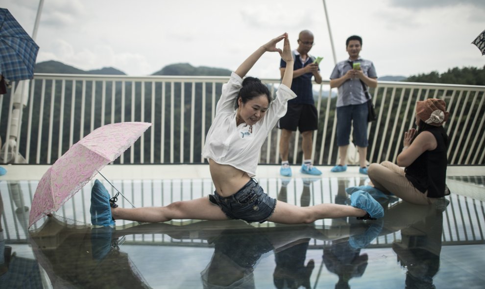 Una mujer posa acrobáticamente  en el puente. FRED DUFOUR / AFP