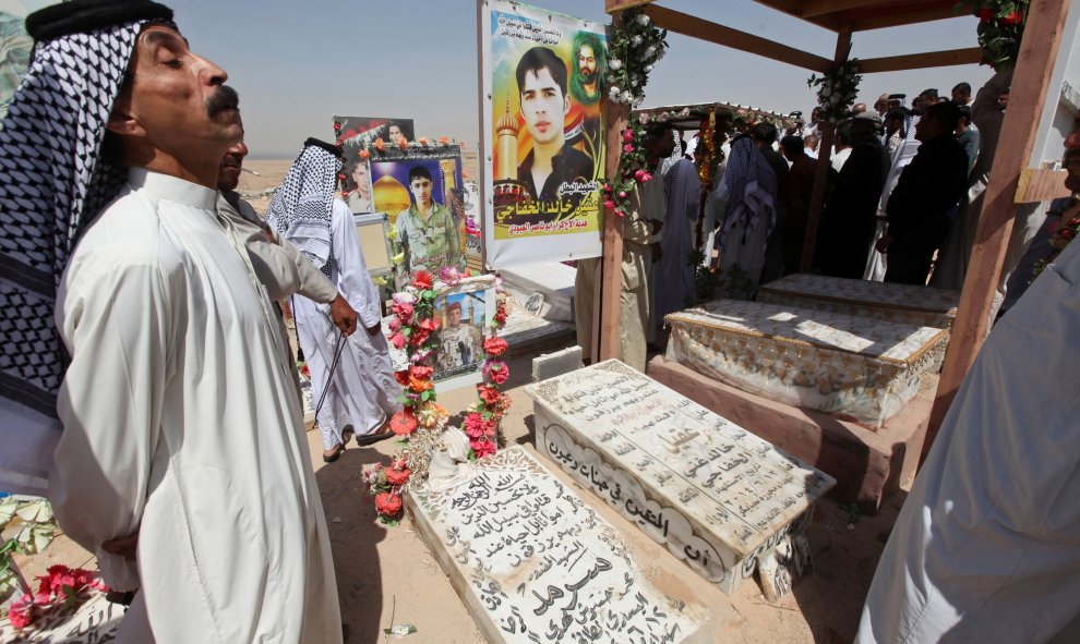 Unos iraquíes visitan las tumbas de sus parientes en el cementerio de Wadi al-Salam (el 'Valle de la Paz), en Nayaf, al sur de Bagdad. REUTERS / Alaa Al-Marjani