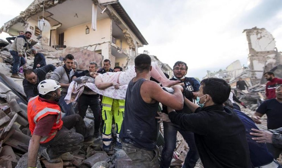 Una mujer herida es rescatada de entre los escombros de un edificio en Amatrice, en el centro de Italia/EFE
