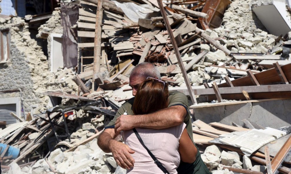 Dos lugareños se abrazan ante varias casas derrumbadas en Pescara del Tronto, cerca de la localidad de Arquata del Tronto, en la provincia de Ascoli Piceno, región de Marche, tras el terremoso en el centro de Italia. EFE/Crocchioni