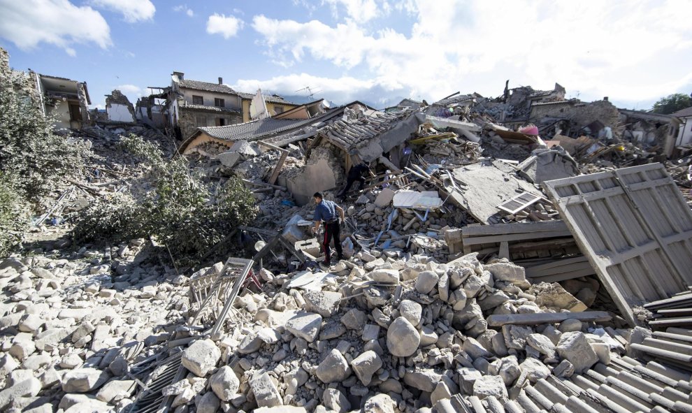 Un carabinero busca supervivientes entre los escombros de un edificio derrumbado en Amatrice,  tras el terremoto que ha sacudido el centro de Italia en la madrugada. EFE/Massimo Percossi