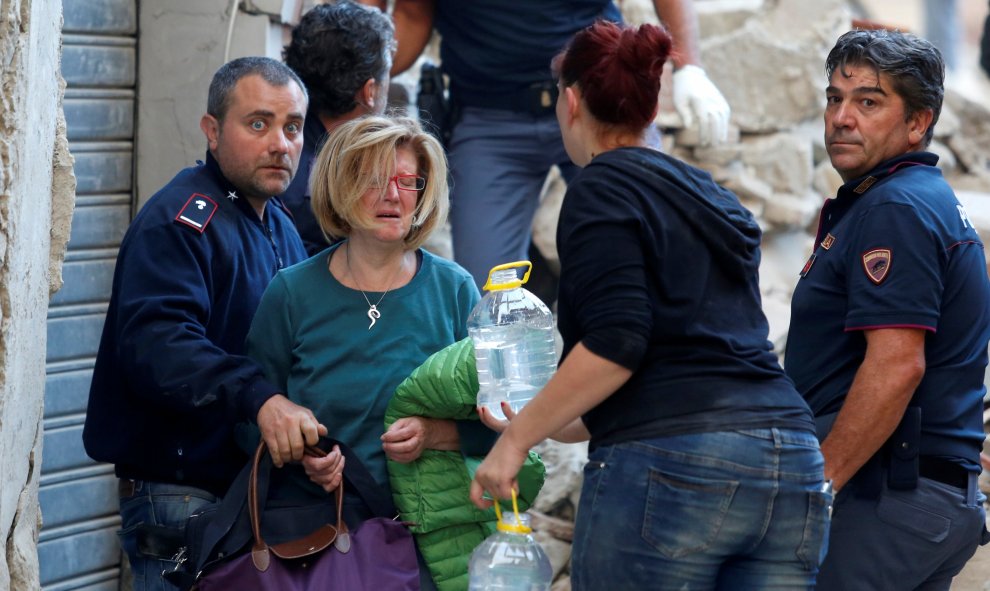 Una mujer es atendida por los equipos de rescate en Amatrice, tras el terremoto que ha sacudido el centro de Italia en la madrugada. REUTERS/Remo Casilli