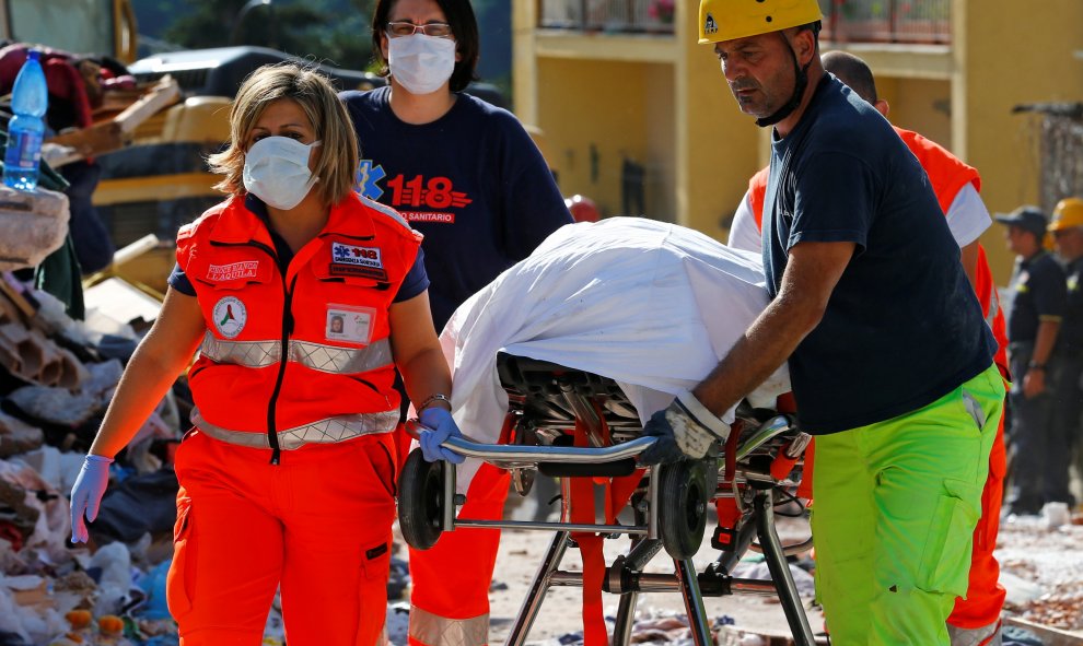 Los equipos de rescate trasladan un cuerpo tras el terremoto. REUTERS/Stefano Rellandini