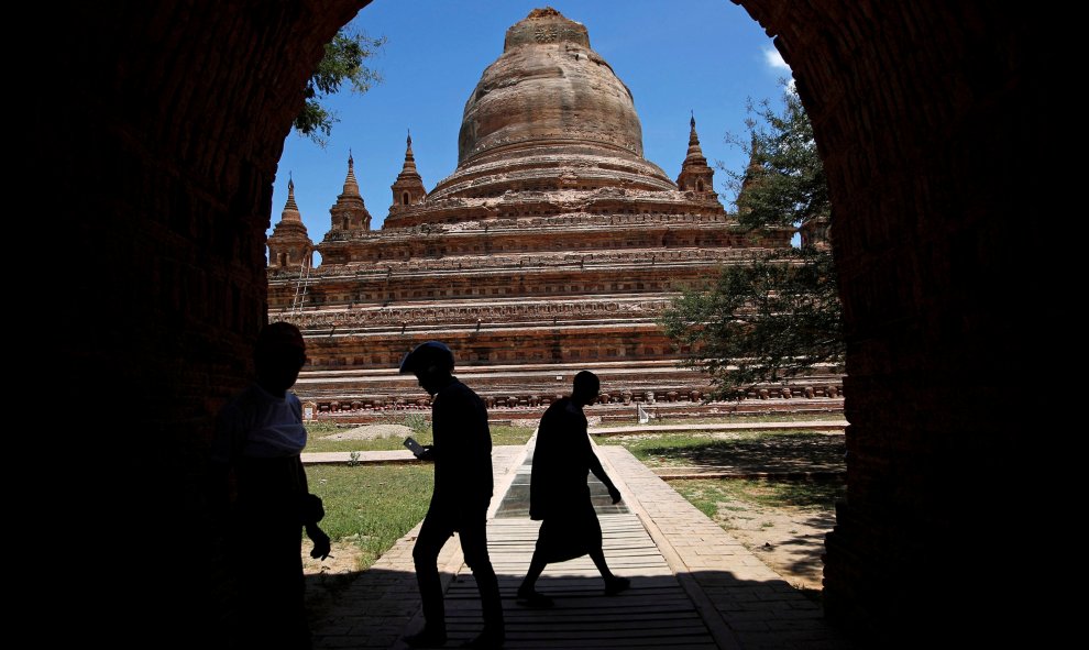 Varias personas pasan junto a una de las pagodas de la región birmana de Pagan dañada tras el terremoto de 6,8 grados que sacudió el país. REUTERS/Soe Zeya Tun