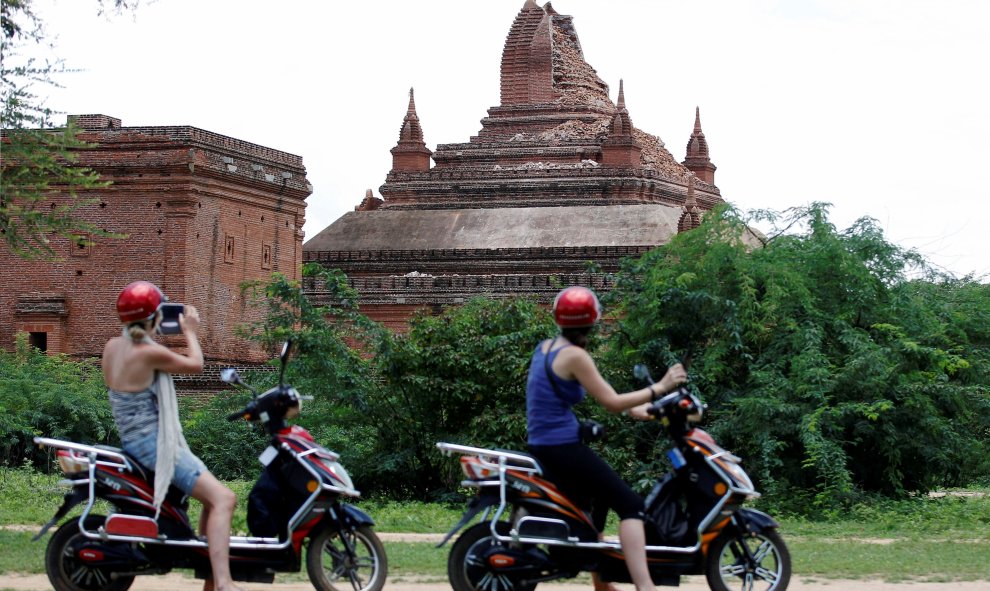 Dos turistas en moto toman fotos de una pagoda de la región birmana de Pagan dañada tras el terremoto de 6,8 grados que sacudió el país. REUTERS/Soe Zeya Tun
