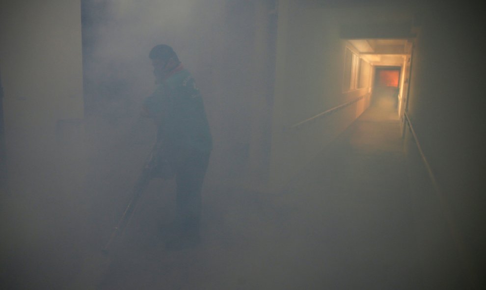 Un trabajador en el pasillo nublado de un parque de vivienda pública donde se descubrió un caso de virus Zika, en Singapur. REUTERS/Edgar Su