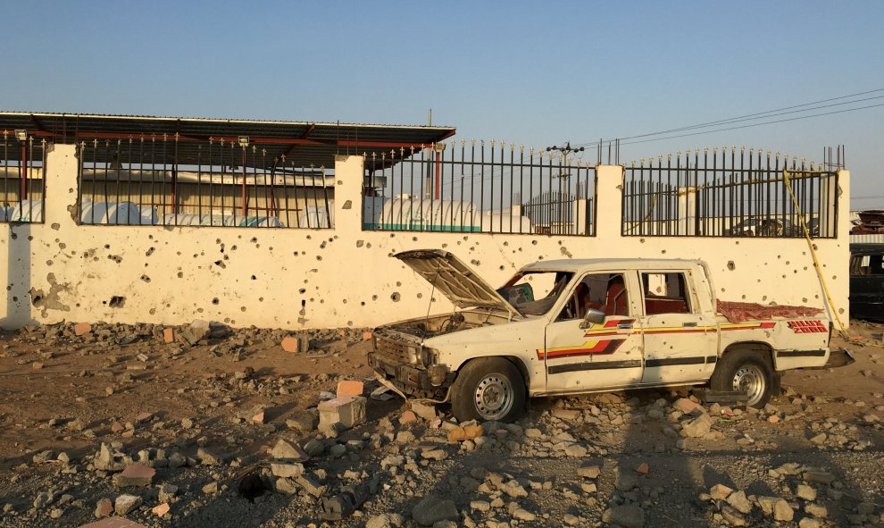 Un coche se encuentra junto a un depósito de chatarra alcanzado por un cohete Houthi en una zona industrial en el este de la ciudad de Najran, Arabia Saudita. REUTERS / Paul Katie