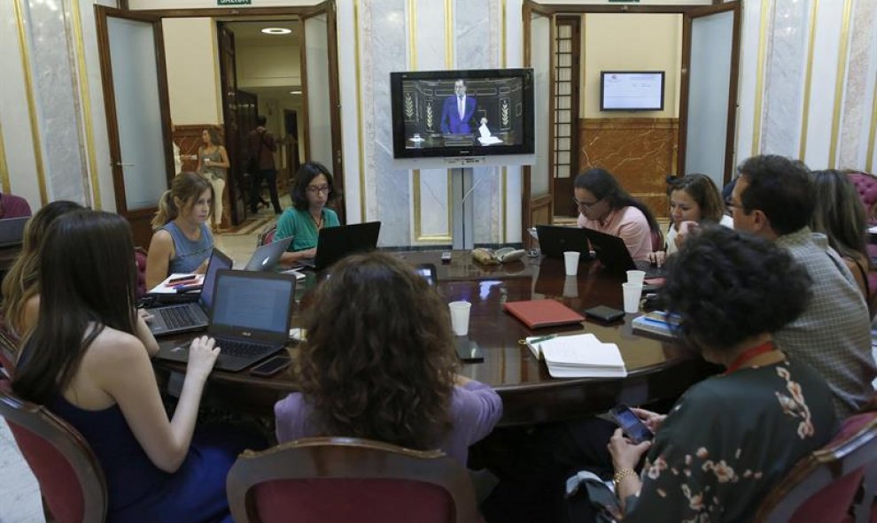 Periodistas siguen por televisión desde una sala del Congreso el discurso de investidura del presidente del Gobierno en funciones, Mariano Rajoy. EFE/Juan Carlos Hidalgo