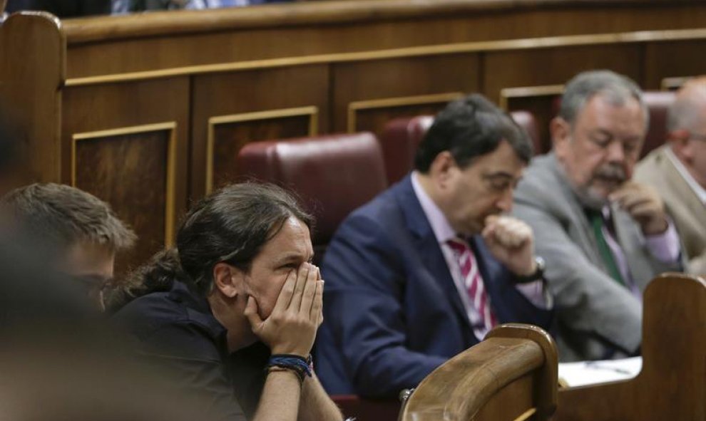 El secretario general de Podemos, Pablo Iglesias (i), escucha hoy desde su escaño el discurso de investidura del presidente en funciones, Mariano Rajoy. EFE/Emilio Naranjo