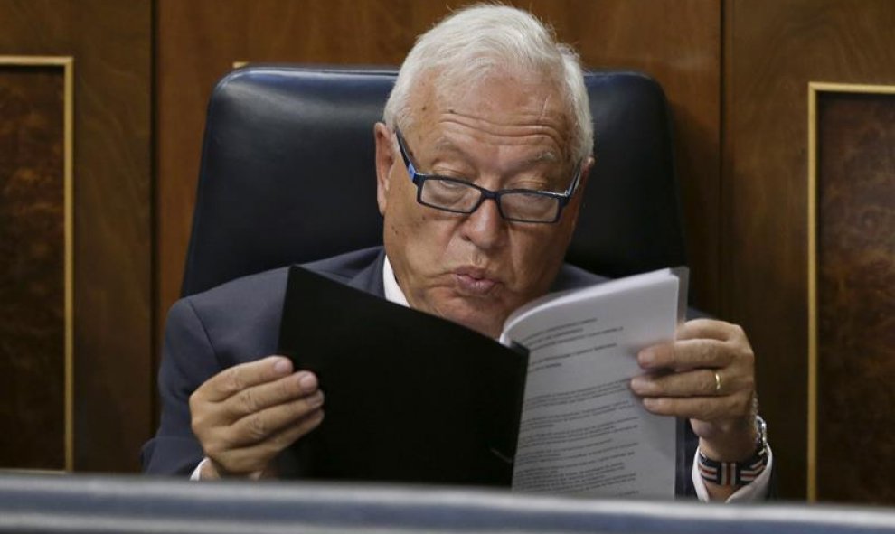 El ministro de Asuntos Exteriores, José Manuel García-Margallo siguen desde su escaño la intervención del presidente del Gobierno en funciones, Mariano Rajoy, durante la primera jornada del debate de investidura a la que se somete, esta tarde en el Congre