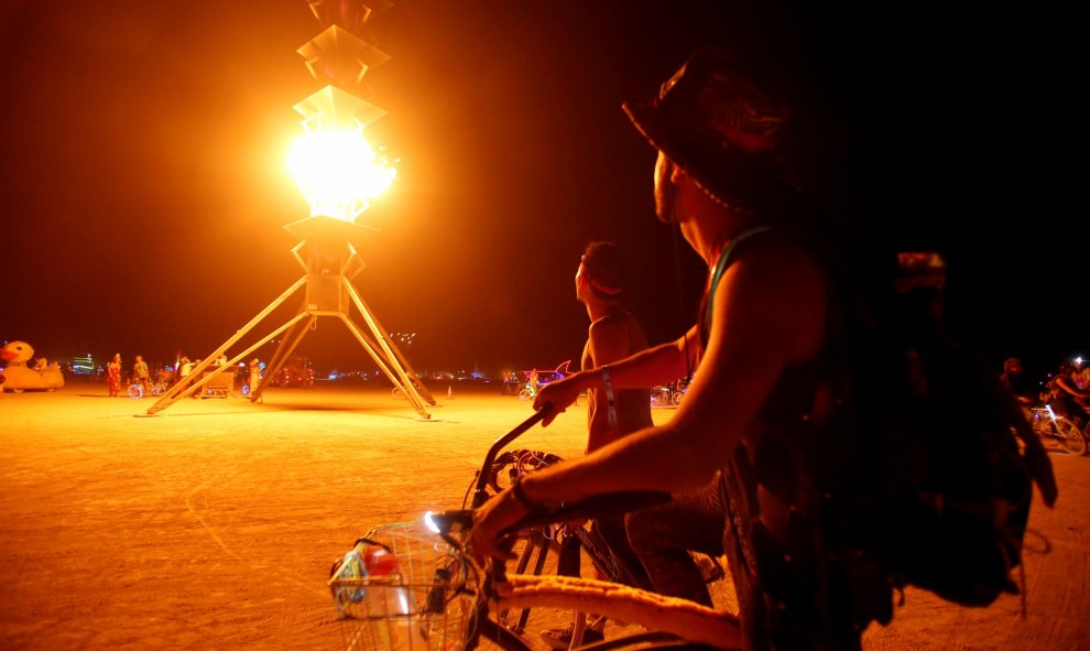 Los participantes observan las llamas en la Aguja de fuego. Aproximadamente 70.000 personas de todo el mundo se reúnen en la 30ª edición anual de "Burning Man", el festival de música en el desierto de la roca negra de la roca de Nevada. REUTERS/Jim Urquha