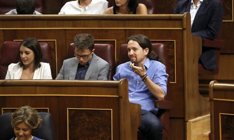 El líder de Podemos, Pablo Iglesias (d) el portavoz del grupo, Íñigo Errejón,c, y su jefa de gabinete, Irene Montero (i), en sus escaños al inicio de la segunda sesión del debate de investidura del líder del PP, Mariano Rajoy, esta mañana en el Congreso