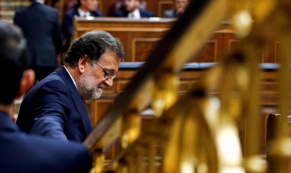 El candidato del PP a la investidura y presidente del Gobierno en funciones, Mariano Rajoy, junto a su escaño en el Congreso de los Diputados, en la segunda sesión del debate de investidura. REUTERS/Andrea Comas