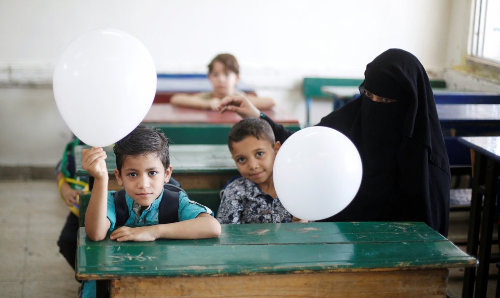 Las madres de niños refugiados palestinos asisten con sus hijos al primer día del nuevo año escolar en una de las escuelas de la UNRWA, situada en un campamento de refugiados palestinos en Amman, Jordania. REUTERS/Muhammad Hamed