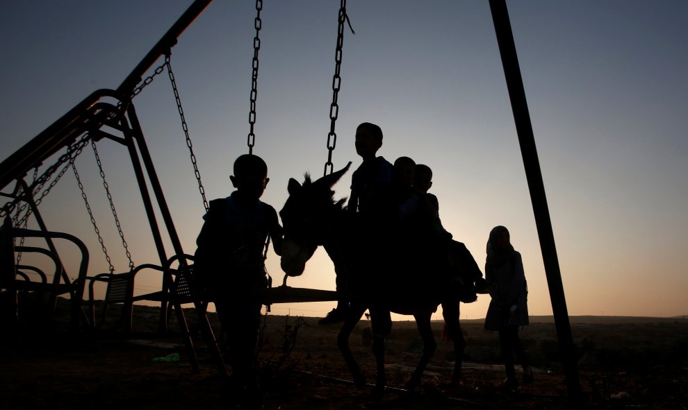 Estudiantes palestinos realizan su trayecto al colegio en la localidad cisjordana de Sosiya, al sur de Hebrón. REUTERS / Mussa Qawasma