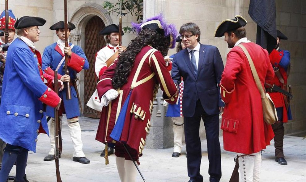 El presidente de la Generalitat, Carles Puigdemont (2d), recibe a una representación de los Miquelets de Cataluña y de la Associació de Recreació Històrica La Coronela en el Palau de la Generalitat, dentro de los actos conmemorativos de la Diada nacional