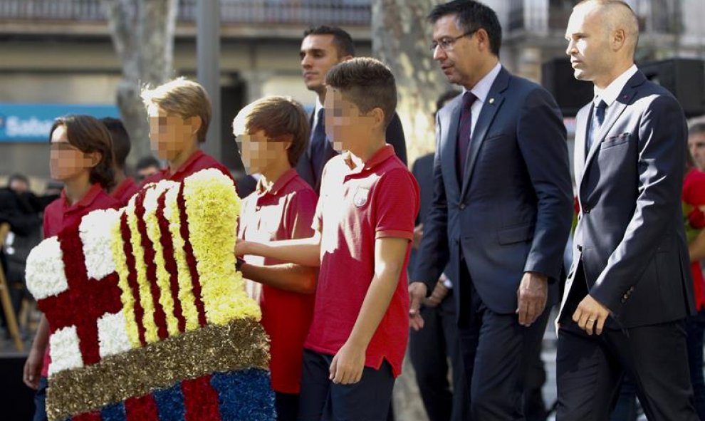 La comitiva del FC Barcelona, encabeada por el presidente, Josep María Martomeu (2d), y el judador Andrés Iniesta (d), asiste a la tradicional ofrenda floral al monumento de Rafael Casanova, dentro de los actos conmemorativos de la Diada nacional de Catal