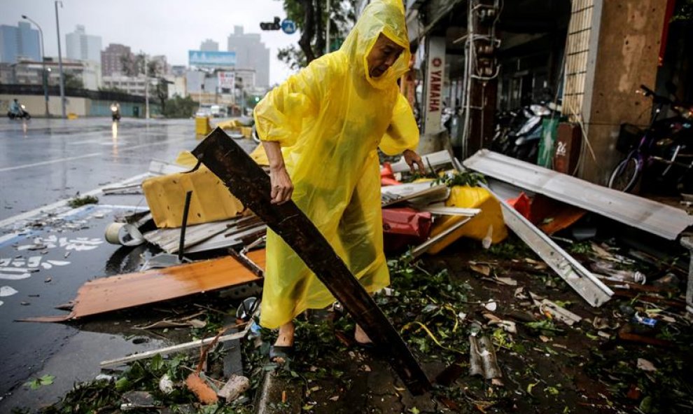 Un hombre busca objetos reutilizables entre los escombros provocados por el azote del viento y la lluvia del supertifón Meranto en Kaohsiung, Taiwán. EFE/Ritchie B. Tongo