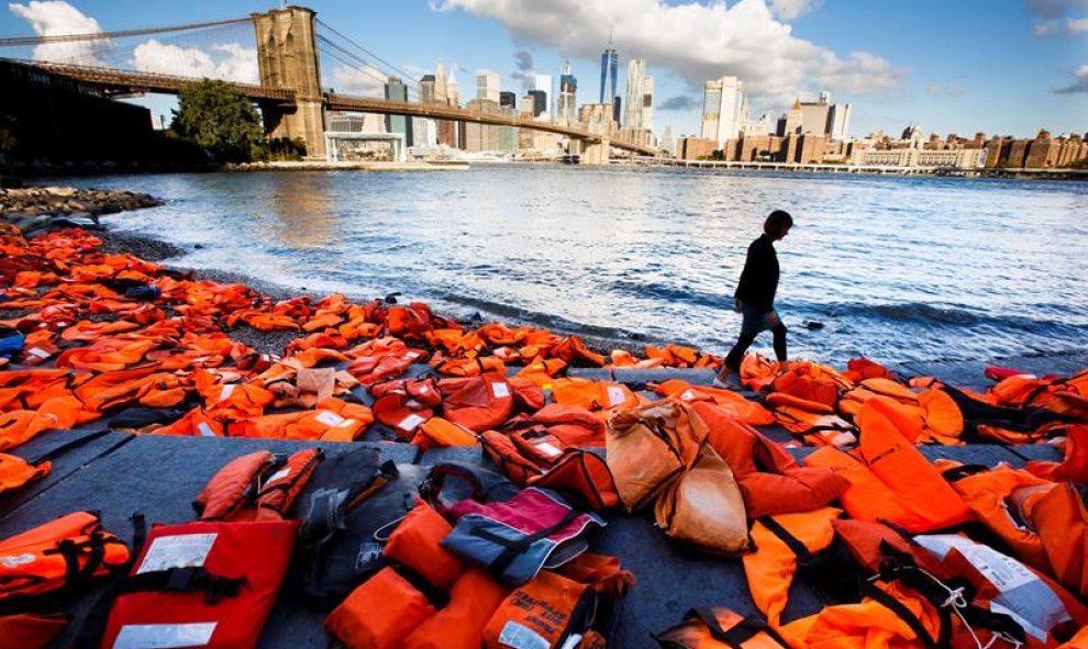 Vista de cientos de chalecos salvavidas de refugiados recogidos en las playas de Chios (Grecia) en la orilla del río Este en Brooklyn, Nueva York, Estados Unidos. EFE/Justin Lane