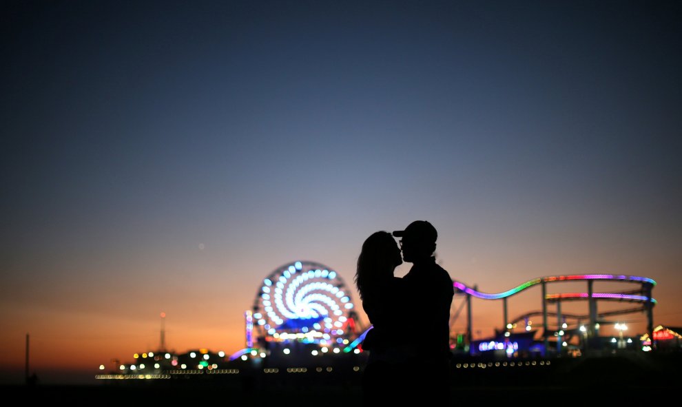 Una pareja se besa enfrente del muelle de Santa Mónica.  REUTERS/Lucy Nicholson