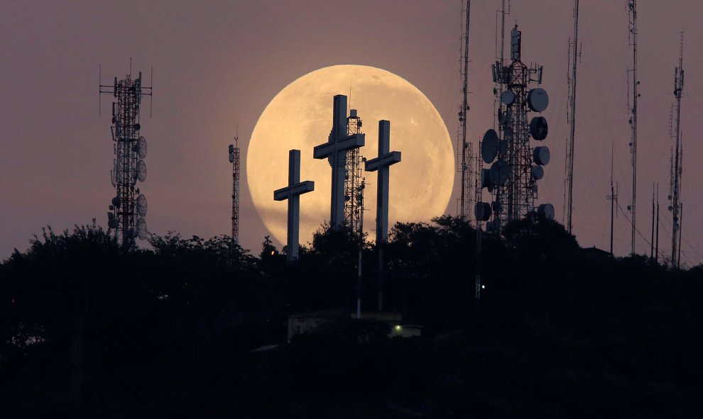 La luna llena se ve detrás de la colina de las tres cruces en Cali, Colombia. REUTERS/Jaime Saldarriaga