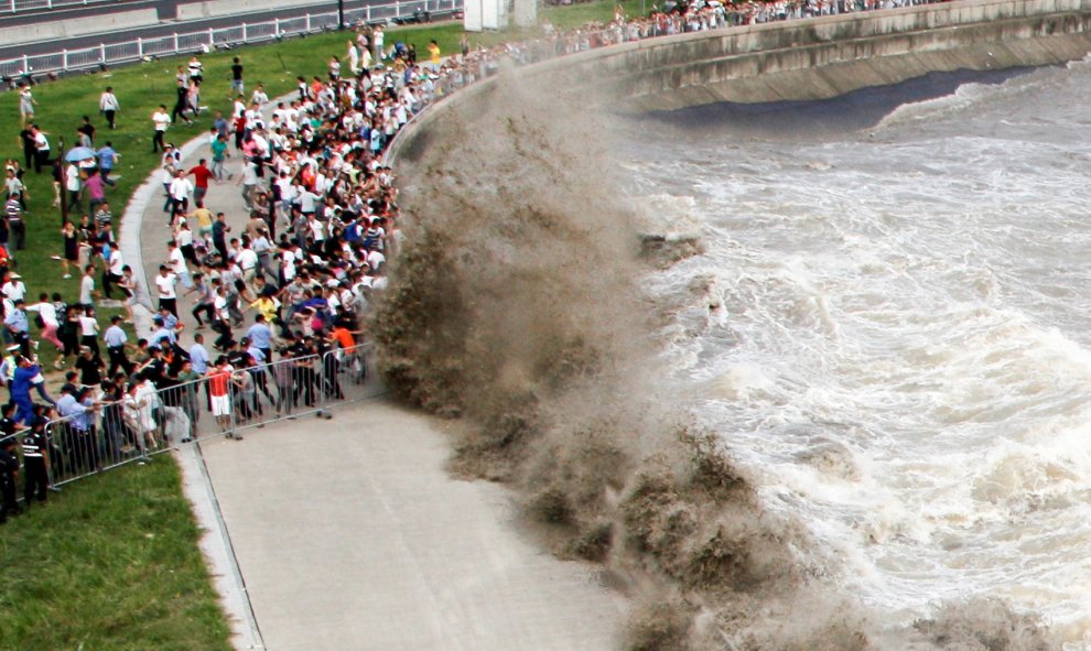 Enormes olas de la mar agitada hacen correr a los paseantes de Hangzhou, provincia de Zhejiang, China. REUTERS / Stringer,