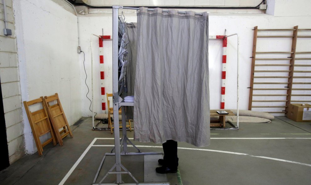Un hombre prepara su voto en una cabina en un colegio electoral en Vigo. REUTERS/Miguel Vidal