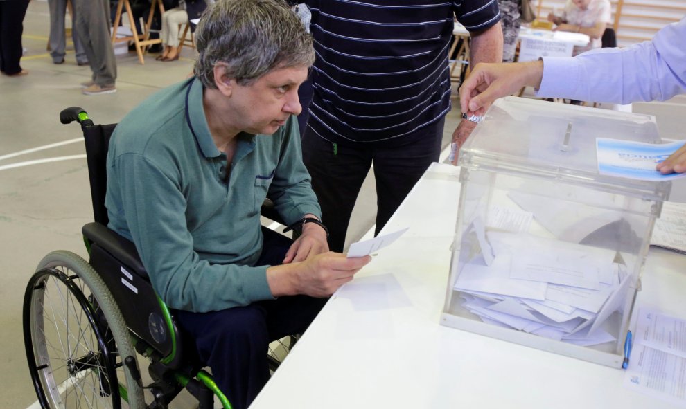 Un hombre en silla de ruedas deposita su voto colegio electoral en Vigo. REUTERS/Miguel Vidal