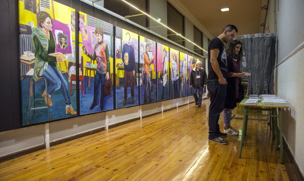 Una pareja escoge su papeleta en el colegio de la Escuela de Artes y Oficios de Vitoria. EFE/David Aguilar