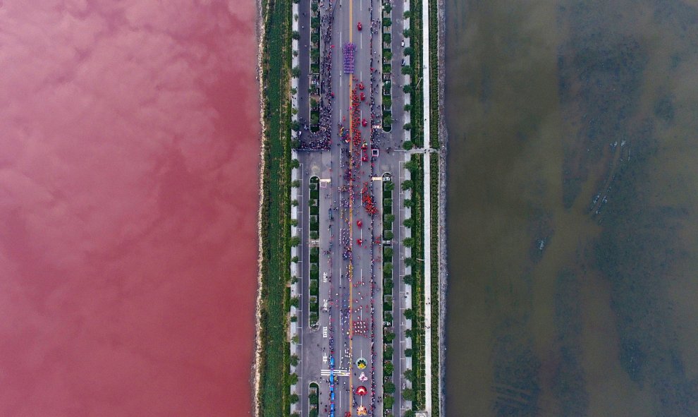 Un lago salado separado por una carretera presenta dos colores diferentes debido a las algas, en Yuncheng, Shanxi Province, China. REUTERS/Wei Liang