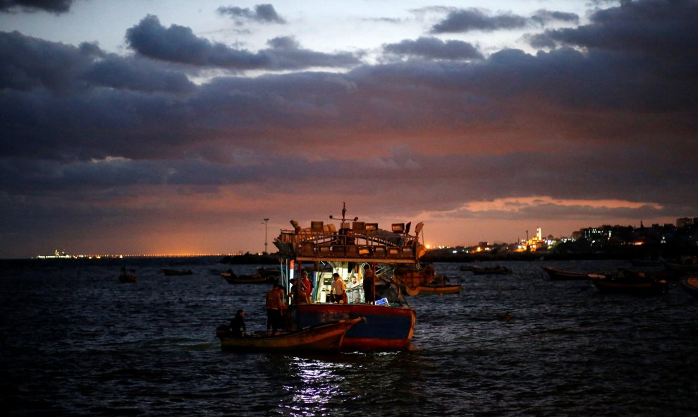 Pescadores palestinos conducen sus barcos al regresan de pescar en el puerto de la ciudad de Gaza. REUTERS/Mohammed Salem