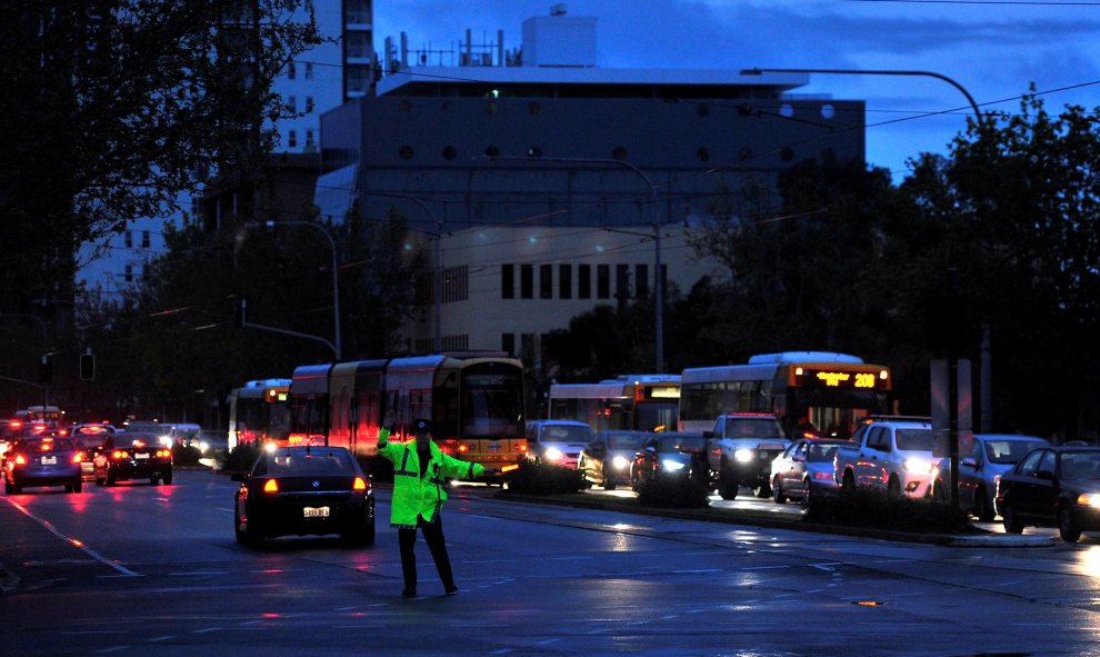 Un policía dirige el tráfico en el distrito central de negocios de Adelaida después de las fuertes tormentas y los miles de impactos de rayos que dejaron sin energía eléctrica a todo el estado de Australia del Sur, Nueva Zelanda. REUTERS
