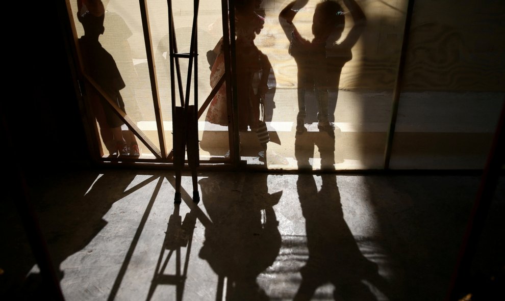 Las sombras de las muletas y los niños se ven durante una fiesta para los pequeños afectados por el conflicto sirio y con necesidad de apoyo psicológico, celebrada en la sitiada ciudad rebelde de Hamouriyeh. REUTERS/Bassam Khabieh