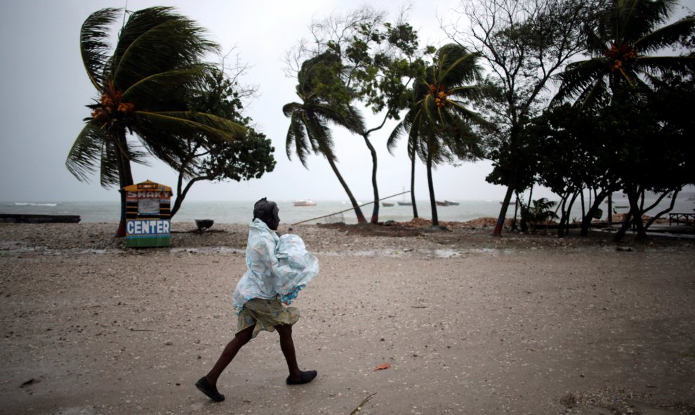 Una mujer se protege de la lluvia que se acerca el huracán Mateo en Les Cayes, Haití. REUTERS / Andrés Martínez Casares
