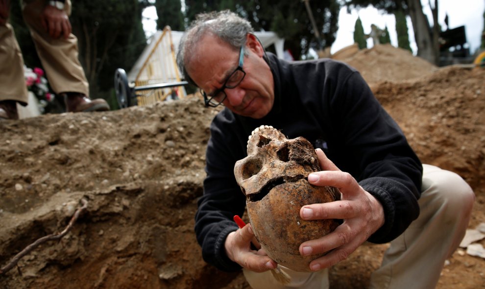 Julio del Olmo, arqueólogo de la ARMH-Valladolid examina el cráneo exhumado en una fosa con alrededor de 200 republicanos fusilados por el bando franquista durante la Guerra Civil, en el cementerio de El Carmen de ValladoliD.- REUTERS -JUAN MEDINA