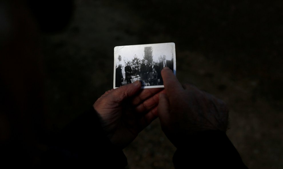 Abilio Pérez sostiene una fotografía de familia cerca de la fosa común donde se cree que su suegro fue arrojado después de haber sido asesinado por las fuerzas de Franco durante la Guerra Civil, en el cementerio de El Carmen en Valladolid.- REUTERS / Juan