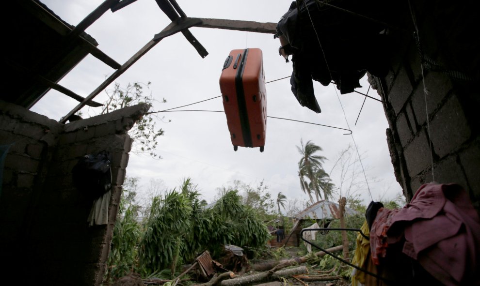 Una maleta cuelga de los restos del tejado destruido de una casa por el huracán Matthew en Les Cayes, Haiti.  REUTERS/Andres Martinez Casares