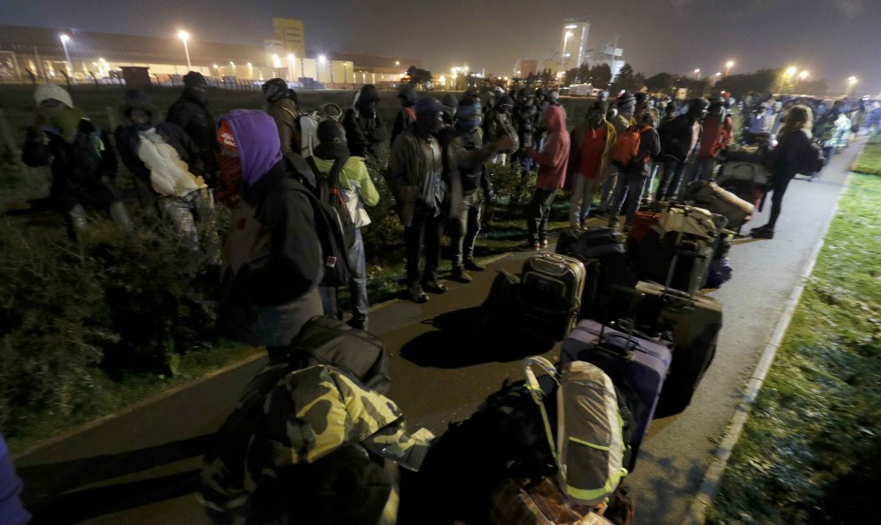 Refugiados del campo de refugiados de Calais esperando el traslado a los centros provisionales que Francia ha habilitado. REUTERS/Philippe Wojazer