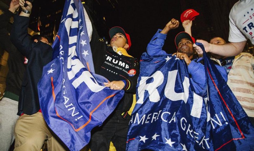 Simpatizantes del candidato republicano Donald Trump congregados a las puertas del New York Hilton Midtown de Nueva York (Estados Unidos) en la noche del 8 de noviembre. EFE/Alba Vigary