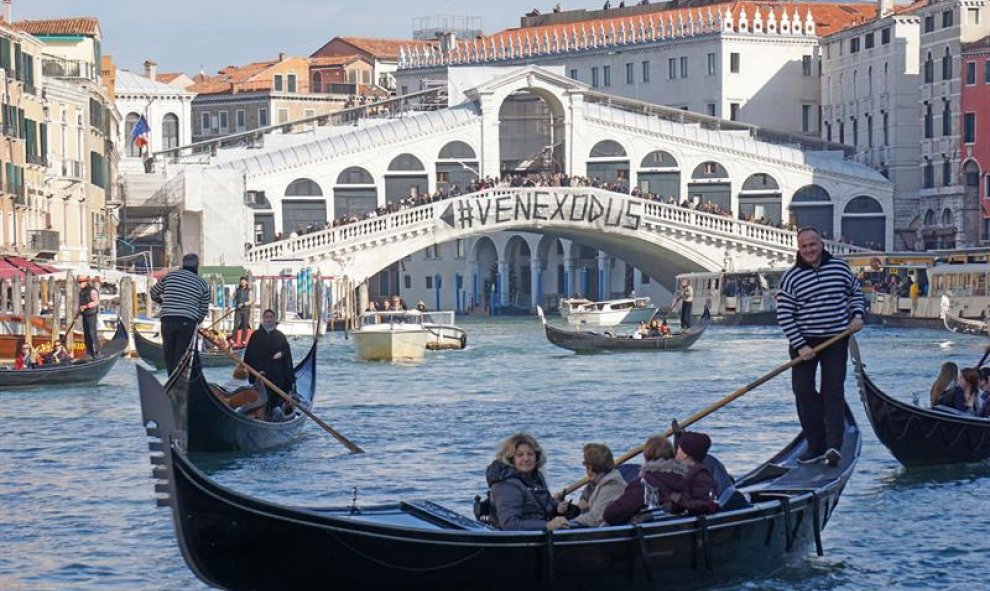Una bandera en el Puente Rialto en Venecia (Italia) donde se lee 'Venexodus', colgada por los ciudadanos que protestan por el creciente número de turistas en la ciudad. / EFE