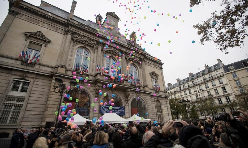 Varias personas lanzan globos al aire en la conmemoración de los atentados de París hace un año./ EFE