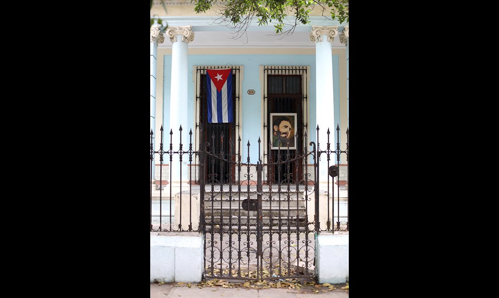 Una bandera cubana y un retrato de Castro cuelgan de una puerta en El Vedado. /Marian León y Lucía M. Quiroga