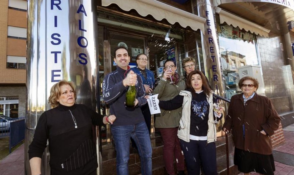 La vendedora de un quinto premio de la loteria de navidad, el número 22259, Carolina Abellán (2d), junto a su madre, dueña del la floristería y ferretería, Mari Carmen Espinosa (i), y su marido, Pedro Francisco Navarro (2i), celebran la venta del número a