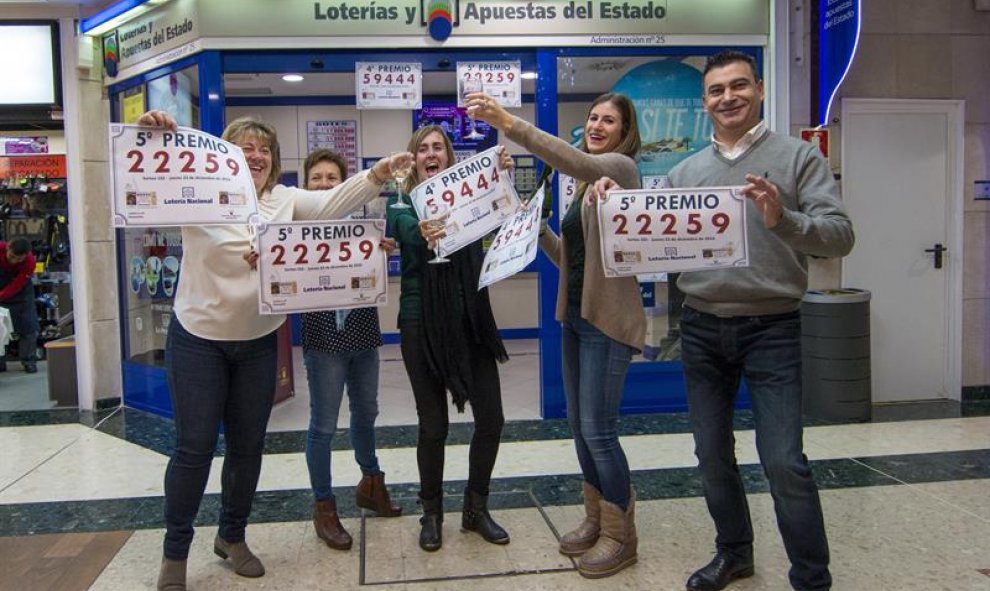 El dueño de la Administración de Lotería Nº25 de Santander, José Miguel Bezanilla, acompañado de su hija, Andrea Bezanilla (2d) y trabajadores del establecimiento, celebran tras averiguar que han vendido un quinto premio, el número 22259, premiado con 60.