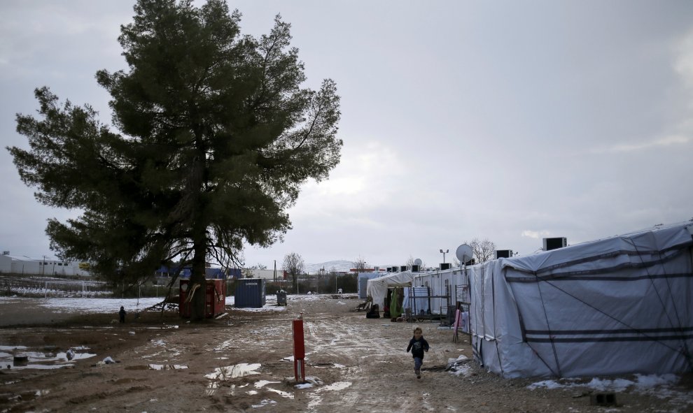 Un niño juega con la nieve en el campo de refugiados de Ritsona, en el norte de Atenas, Grecia. REUTERS/Alkis Konstantinidis